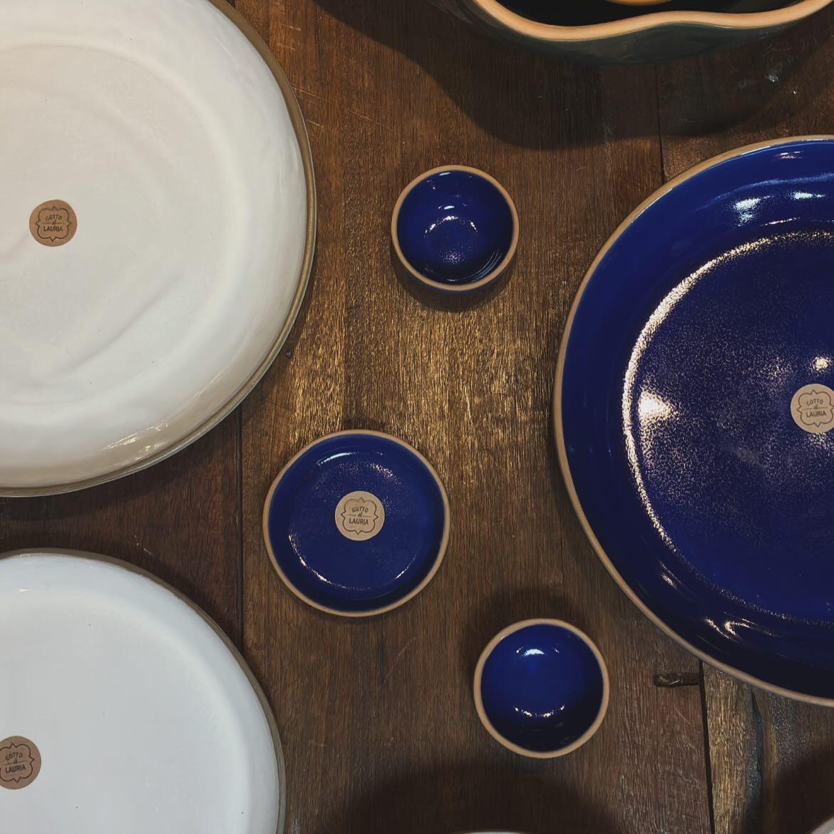 Composição com pratos brancos, mini-bowls azul cobalto e tigela verde esmeralda