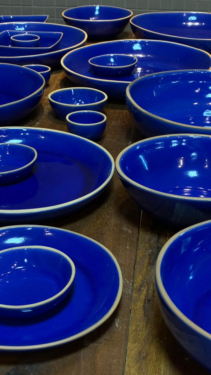Peças azul cobalto com selo COTTO di LAURIA — desenvolvimento exclusivo para operações gastronômicas