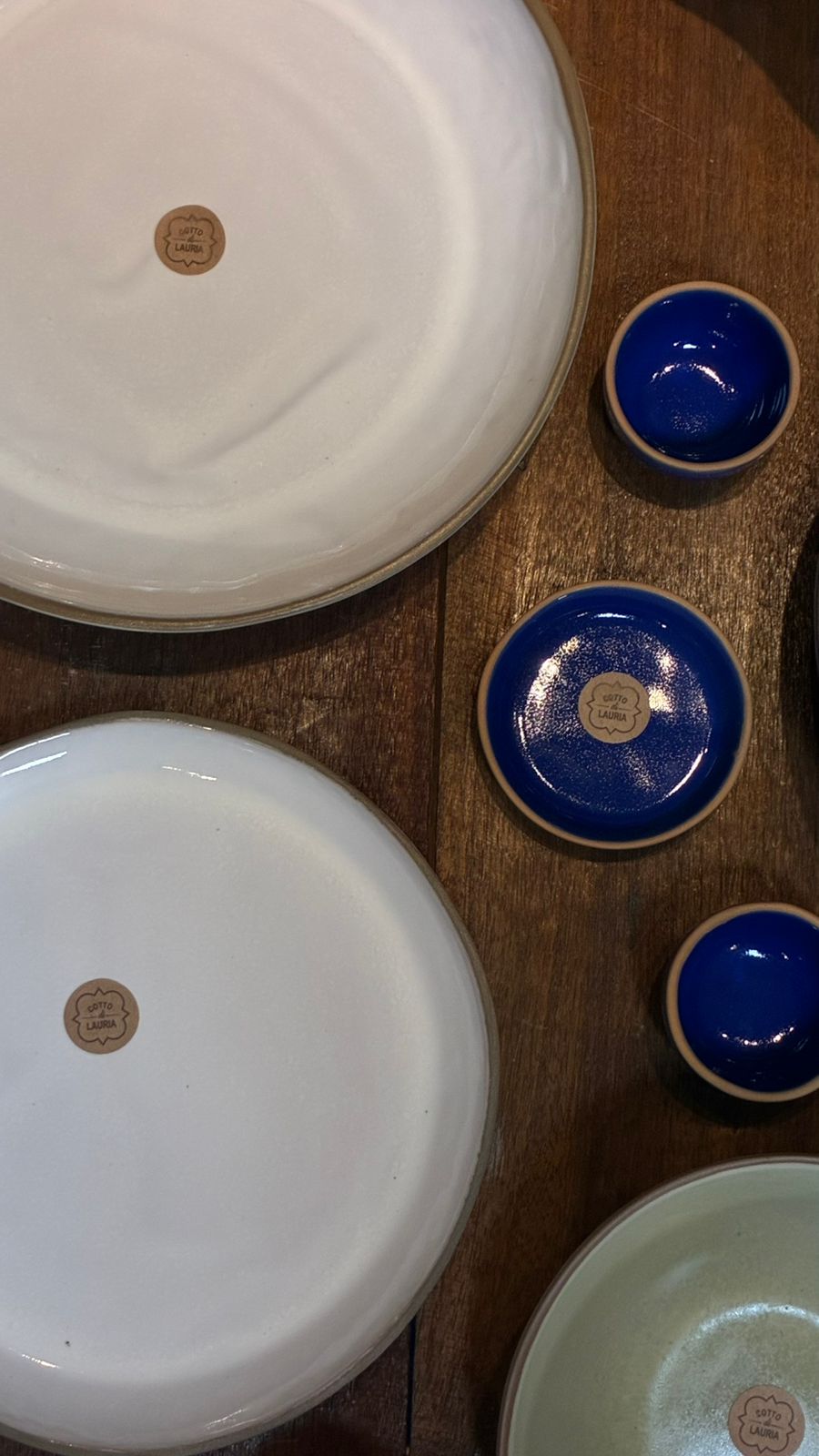 Pratos brancos com selo da marca e tigelas azul cobalto